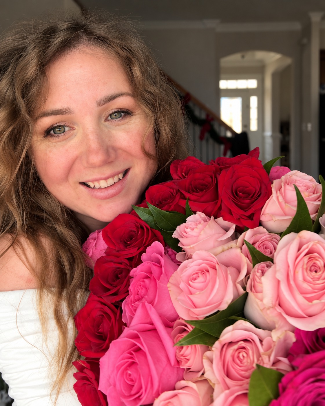 Marina smiling with a bouquet of pink and red roses