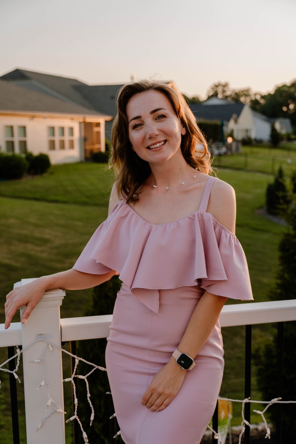 Marina smiling in a pink dress outdoors
